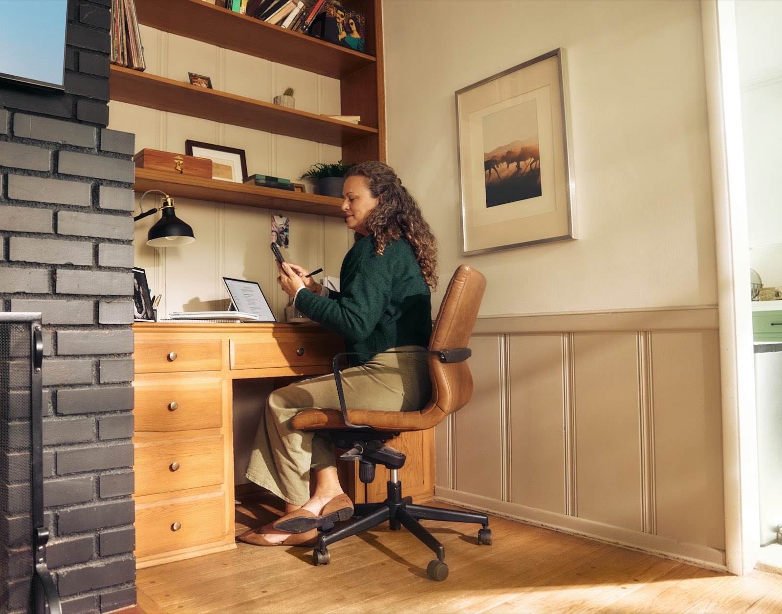 Ondernemer aan een bureau thuis, met telefoon en laptop